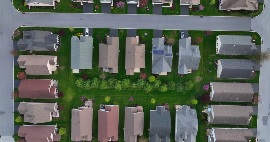 New compact housing in suburbs of USA. American urban population growth, sprawl concept. Top down aerial of rooftops.