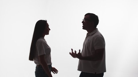 Silhouette of man from rage and anger strangling woman, white background in studio, side view. Man in fit of rage begins to strangle woman. Concept rage and madness