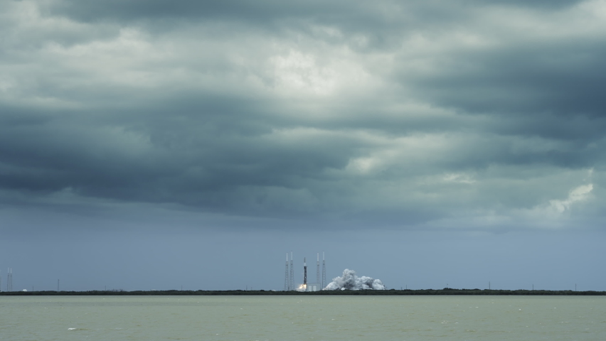 Space Rocket blasts off from Florida space center launch pad to deliver commercial satellites into orbit in space. Includes audio. 4K wide shot.