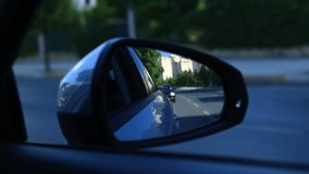 View in the rear view side mirror of a auto, driving a car along the track