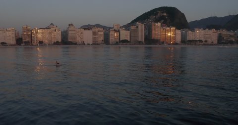 Drone Shot of a Person doing Stand Up Paddle with a dog in Copacabana Beach, Rio de Janeiro - Brazil