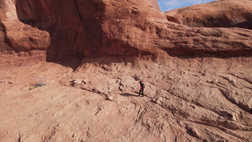 Aerial shot of an Asian woman hiking through the amazing landscape near Moab Utah, USA.