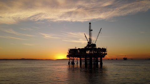 Aerial shot of an offshore oil platform at sunset