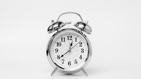 Time lapse of retro alarm clock running isolated on white background. Twelve o'clock on The New Years of the beautiful alarm clock face. Stop motion Animation of Alarm clock running.