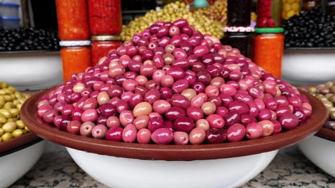 Pile of red Moroccan olives in the souk, Medina, in Marrakech (Marrakesh), Morocco. Food background footage in 4k. 