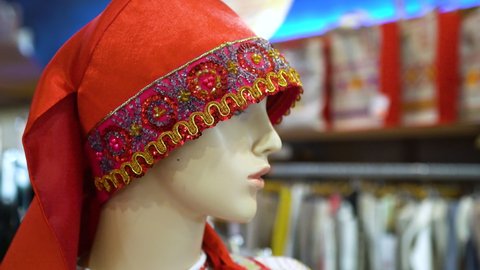 Panorama of the head of a mannequin in a red cap with embroidery. Close-up. The red cap is pulled over the eyes.