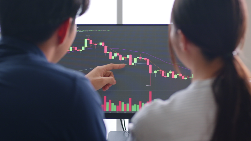 Young Asian investors analyzing about stock market and cryptocurrency investment from graph in computer laptop together. | Shutterstock HD Video #1089781739