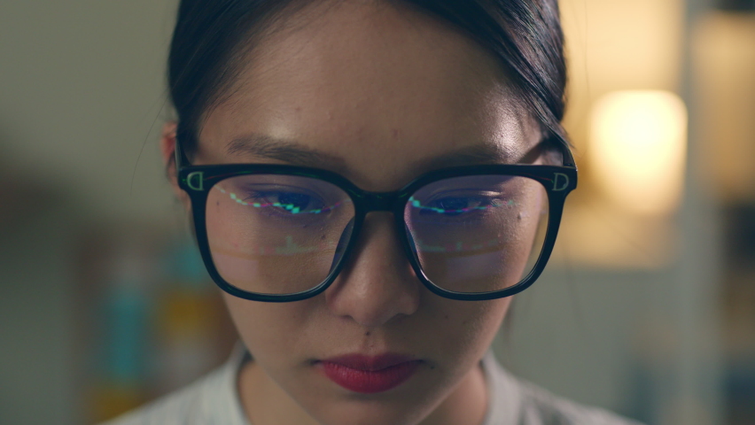 Stock trading woman wearing eyeglasses looking at computer screen reflecting in glasses analyzing stock trading graph. Close up of eyes refection Royalty-Free Stock Footage #1089782579