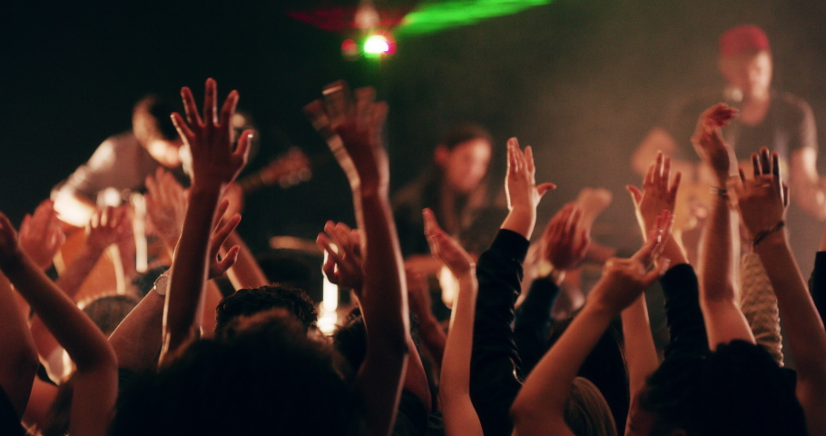 The band that brought everyone together. 4k video footage of a crowd of people cheering and dancing during a live musical performance.