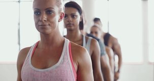 The fitness line-up. 4k video of a group of sporty young people walking in a line at the gym.