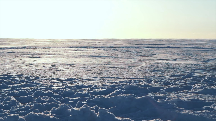 500 FPS SLO MO: Man snowmobiles up hill and makes powder turn with Grand mountains in background. snowmobilers sports riding. bright skidoo motorbike and suit. Pro snowmobiler, Winter fun moto extreme
