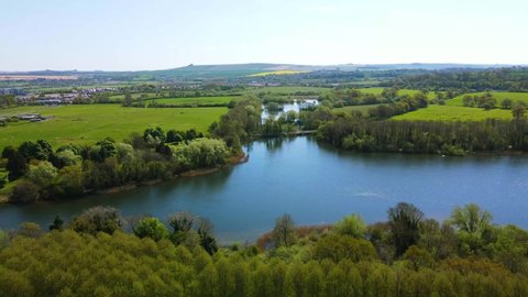 Aerial video of Coate Water Country Park, Swindon, Wiltshire, revealing the beauty of the park, its attractions such as the golf course and its beautiful lake on a sunny day