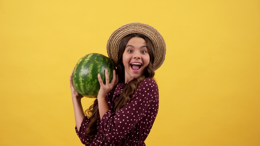 happy child in straw hat hold water melon on yellow background, watermelon