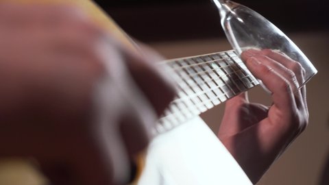 Skilled hands play acoustic guitar on concert.