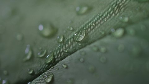 Macro close-up studio shot of water drops on a waterproof polyester membrane Gore-Tex camping tent fabric