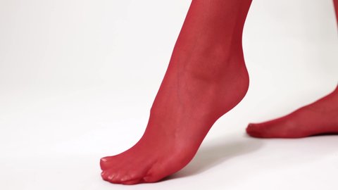 Woman puts on a classic red stocking with a mesh on her beautiful legs - close-up 4k video
