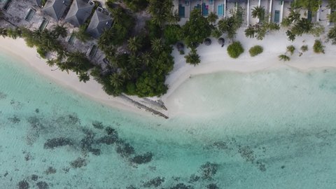 Aerial view of beautiful Maldives island beach villa bungalows resort, top view 4K Sun island drone landscape with swimming pools bungalows