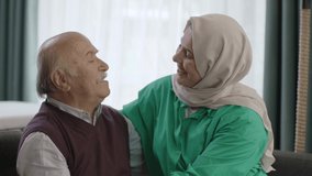 The young woman in a turban is happy to see her father coming to visit. The old man and his daughter are smiling happily at the camera. Portrait of happy father and daughter.Slow motion video.
