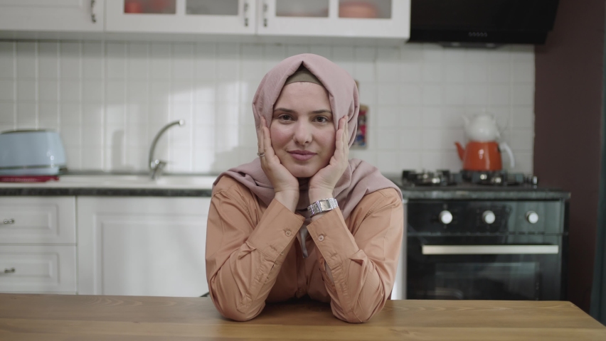 Unhappy depressed woman. Stressed from work, worried, heartbroken. Young woman wearing hijab thinking head in hands sitting alone in kitchen at home. | Shutterstock HD Video #1089794813