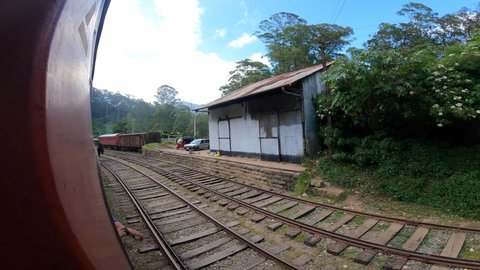 Nuwara Eliya, Sri Lanka - February 25 2022: Old Srilankan Train passing through a small village with junk train standing old trains of Asia