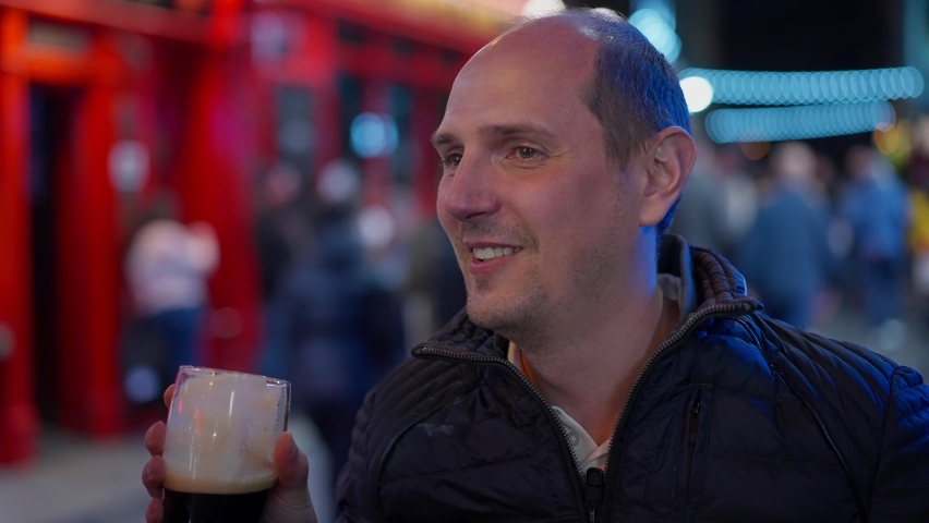 Guys drinking a beer in the Temple Bar district of Dublin by night - Ireland travel photography