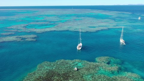 flying over the great barrier reef in the whitsundays, over a yacht, in queensland, Australia.