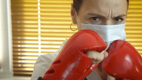 Fight against the spread of infection. A stressed medical worker in red boxing gloves fight against virus infection in quarantine. - Powered by Shutterstock - Get 15% off with code: PIKWIZARD15