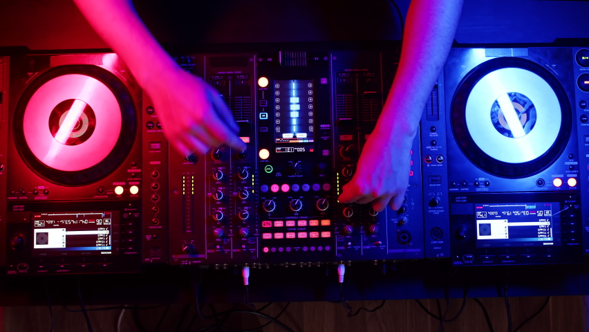 Setting up digital mixing console with hands of DJ, top view. Confident DJ sets up fader on digital music console. Concept modern musical accompaniment of events Royalty-Free Stock Footage #1089801357
