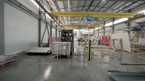 Forklift Machine Moves Blocks Of Granite Stone In Industrial Production Plant. Workers Attaching Hooks Of Crane To Stone Slabs In Production Plant. Heavy Equipment Of Stone Production Plant. Industry