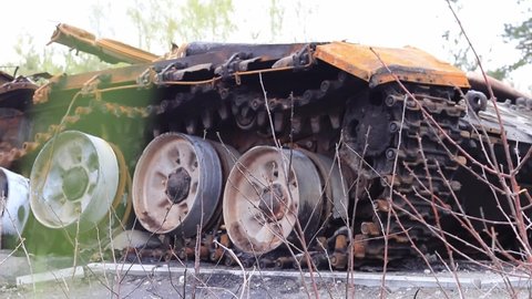 Ukraine, Dmytrivka, Kyiv Oblast - 04.26.2022: Burnt Russian tank near the road. Consequences of Russia's invasion of Ukraine 2022. Close-up, fragment of military equipment