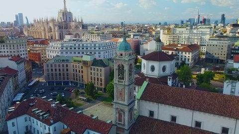 Aerial view of the Basilica of Santo Stefano Maggiore in the center. Drone view of the rooftops during the day. church. Stone building. Bell tower. People in the city. Milan. Italy April 2022
