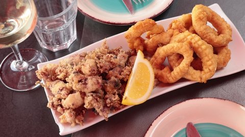 Popular appetizer of Spanish cuisine is squid a la romana and baby andalusian squids served with a slice of lemon. High quality 4k footage