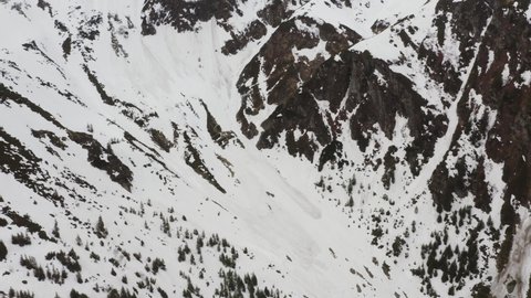 4k video. Avalanche on top of the mountain when winter changes to spring. Aerial view of some big avalanches trails. Danger for hiking.