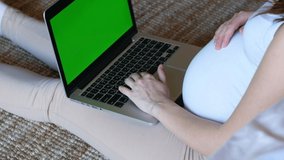 Pregnant woman sitting on the floor working on her laptop. Pregnancy and work. - Powered by Shutterstock - Get 15% off with code: PIKWIZARD15