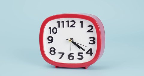 Timelapse 2 hours, Red Alarm clock isolated on blue background,Startime 03.00 am.
