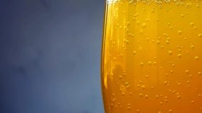 Bubbles of orange soda in a glass close-up whit wet on a gray background. Wet glass with pop orange soda. 4k macro video 60 fps.
