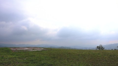 Helipad on the mountain. The mountain scenery has a blue sky in the background with fog covering the sky.