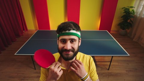 Charismatic funny ping pong player came closeup to the camera get ready to start the game then take his racket and start to playing the table tennis game