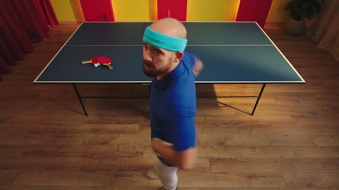 Good looking guy ping pong player after he win the ping pong game get very excited with energy start to dancing crazy looking straight to the camera and have a funny face