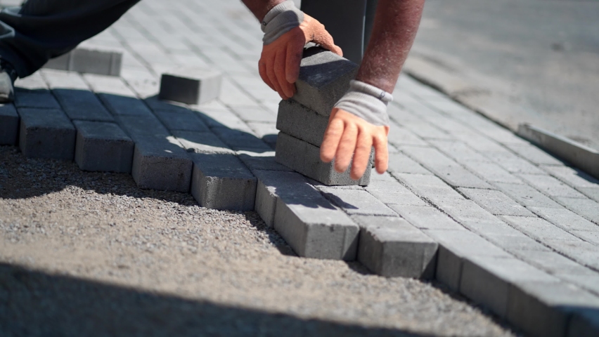 workers lay paving tiles, construction of brick pavement, close up architecture background, slow motion Royalty-Free Stock Footage #1089823651