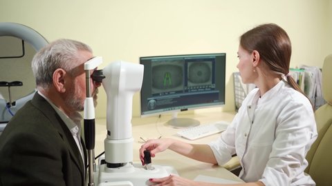 ophthalmologist examination of the elderly man on the corneal topographer. Videokeratograph is medical device for determining curvature of cornea. mandatory device for modern clinic or opticians shop.