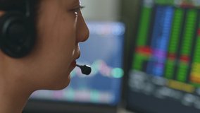 Close up of young Asian woman broker wearing headphone, call center, customer service talking with customer and trading stock. - Powered by Shutterstock - Get 15% off with code: PIKWIZARD15