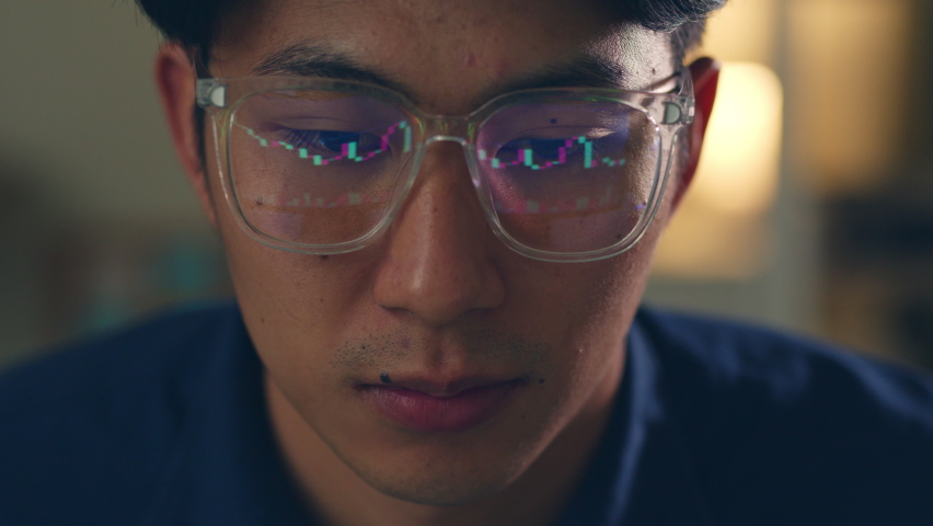 Stock trading man wearing eyeglasses looking at computer screen reflecting in glasses analyzing stock trading graph. Close up of eyes refection | Shutterstock HD Video #1089827495