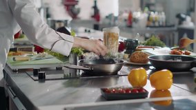Professional cook preparing gastronomy dish in frying pan, using ingredients and kitchen utensils. Authentic female chef cooking gourmet meal with culinary food recipe on stove. Handheld shot. - Powered by Shutterstock - Get 15% off with code: PIKWIZARD15