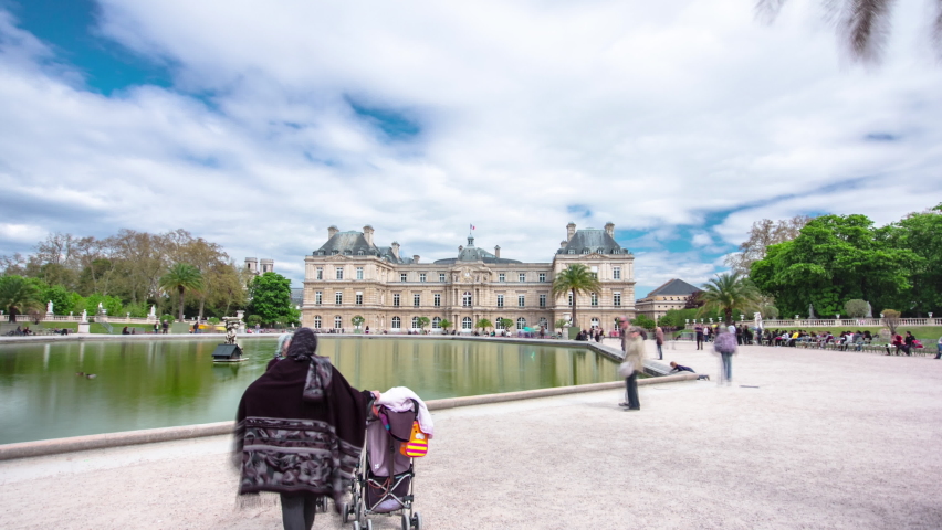 The Luxembourg Palace in The Jardin du Luxembourg or Luxembourg Gardens in Paris, France. View on the main facade and water fountain pond timelapse hyperlapse