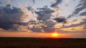 Breathtaking sunset over farmland in summer. Footage from a bird's eye view. Location place Ukraine, Europe. Fast flying clouds in sky. Cinematic clip. Filmed UHD 4k video. Beauty earth.