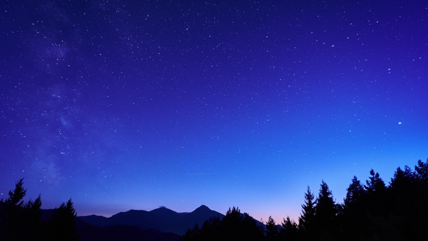 Beautiful blue night sky with the Milky Way in a mountain landscape.Silhouette of trees, mountains Royalty-Free Stock Footage #1089830349