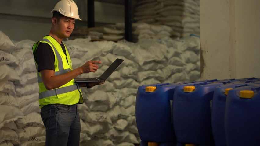A Young manager using laptop counting chemical barrels. 
check stock product in chemical industry. Warehouse worker with laptop. | Shutterstock HD Video #1089830451