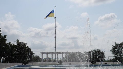 MELITOPOL, ZAPORIZHIA OBLAST, UKRAINE - JUNE 19 2021: view centre of Melitopol with Ukrainian flag and fountain in slow motion