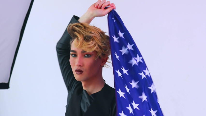 Closeup portrait of a young man with a lipstick wrapped on American flag white background